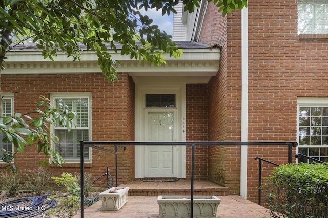 doorway to property featuring brick siding