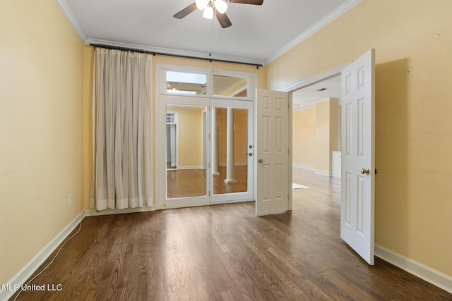 spare room with crown molding, ceiling fan, wood finished floors, and baseboards