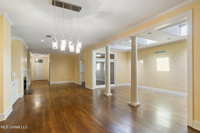 unfurnished living room featuring ornate columns, brick wall, wood finished floors, a fireplace, and baseboards