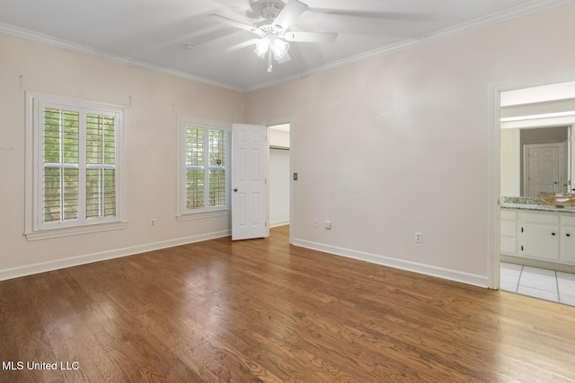 unfurnished room featuring a ceiling fan, light wood-style flooring, ornamental molding, and baseboards