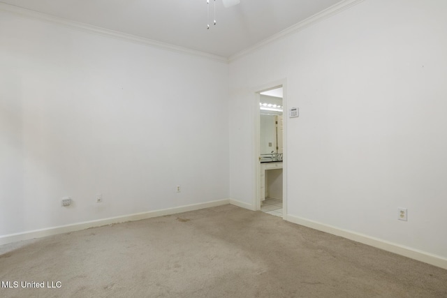 carpeted empty room with ornamental molding, baseboards, and a ceiling fan