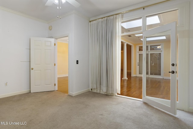 spare room with ornamental molding, ceiling fan, carpet, and baseboards