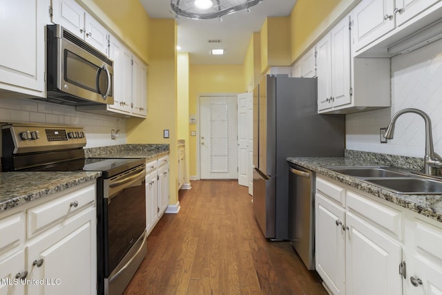 kitchen featuring appliances with stainless steel finishes, a sink, dark wood-style flooring, and white cabinetry