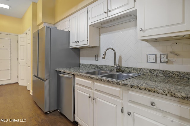 kitchen with stainless steel appliances, a sink, dark wood-style flooring, white cabinetry, and tasteful backsplash