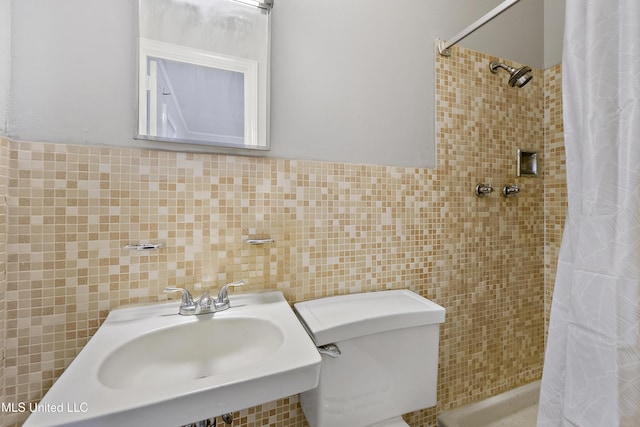 bathroom with toilet, sink, tile walls, and walk in shower