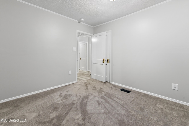 carpeted spare room with ornamental molding and a textured ceiling