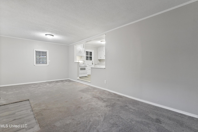 unfurnished living room with carpet, a textured ceiling, and ornamental molding