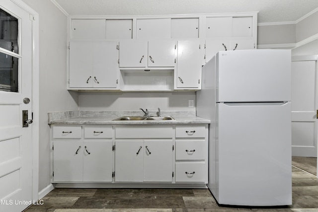 kitchen with ornamental molding, sink, white cabinets, white fridge, and dark hardwood / wood-style floors