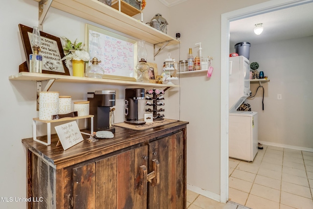 2211 Popps Ferry Rd, Biloxi, MS 39532 - bar area featuring tile patterned floors, stacked washer / drying machine, and baseboards