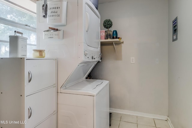 2211 Popps Ferry Rd, Biloxi, MS 39532 - laundry room with stacked washer and clothes dryer, baseboards, and light tile patterned flooring