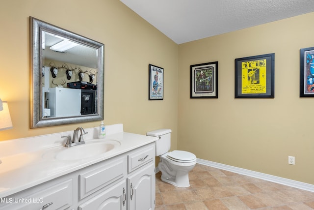 bathroom with vanity, a textured ceiling, and toilet