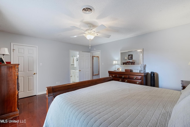 bedroom featuring ensuite bath, ceiling fan, dark wood-type flooring, and a textured ceiling