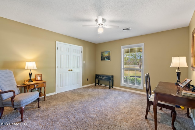 carpeted office space with ceiling fan and a textured ceiling