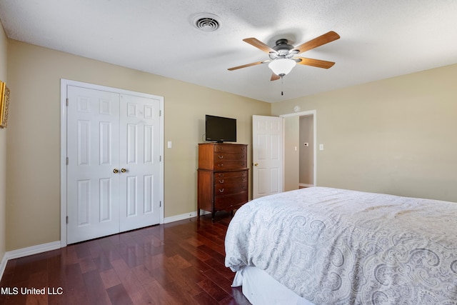 bedroom with a closet, ceiling fan, dark hardwood / wood-style flooring, and a textured ceiling