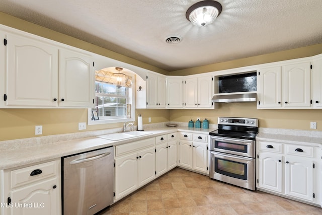 kitchen featuring a textured ceiling, white cabinetry, sink, and appliances with stainless steel finishes