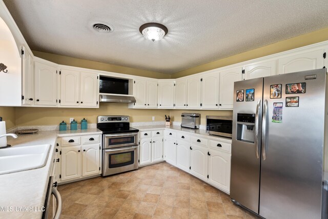 kitchen featuring sink, white cabinets, stainless steel appliances, and a textured ceiling