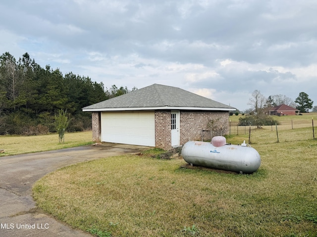 view of side of property featuring a garage, a yard, and an outbuilding