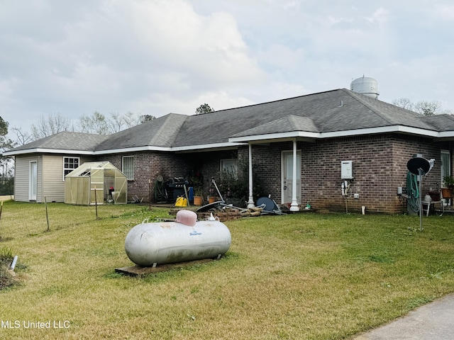 back of house featuring an outdoor structure and a lawn