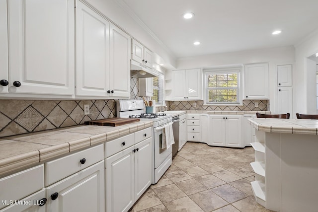 kitchen with tile counters, white cabinets, white gas stove, under cabinet range hood, and open shelves