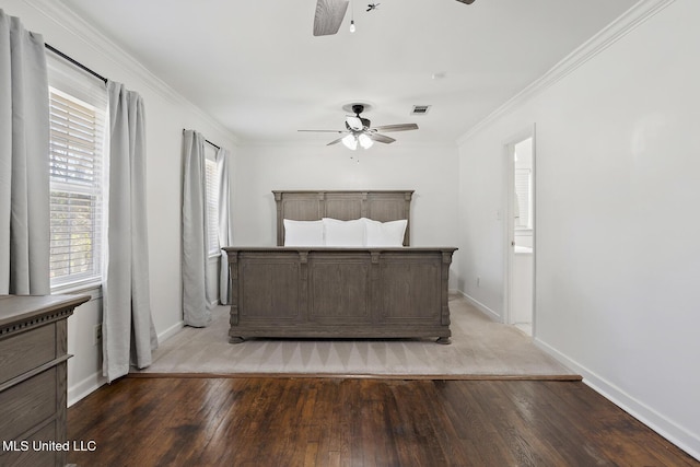 unfurnished bedroom with baseboards, visible vents, ornamental molding, and wood finished floors