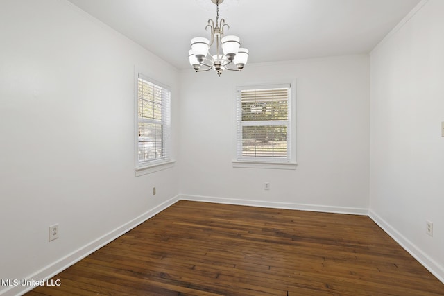 unfurnished room with a notable chandelier, crown molding, baseboards, and dark wood-type flooring