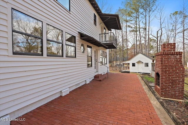 view of home's exterior featuring a balcony and an outbuilding