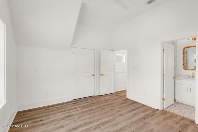 26470 W Beach Blvd, Pass Christian, MS 39571 - unfurnished bedroom with lofted ceiling, light wood-type flooring, and ensuite bath