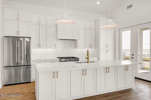 26470 W Beach Blvd, Pass Christian, MS 39571 - kitchen featuring high end refrigerator, white cabinets, light countertops, light wood-style floors, and recessed lighting