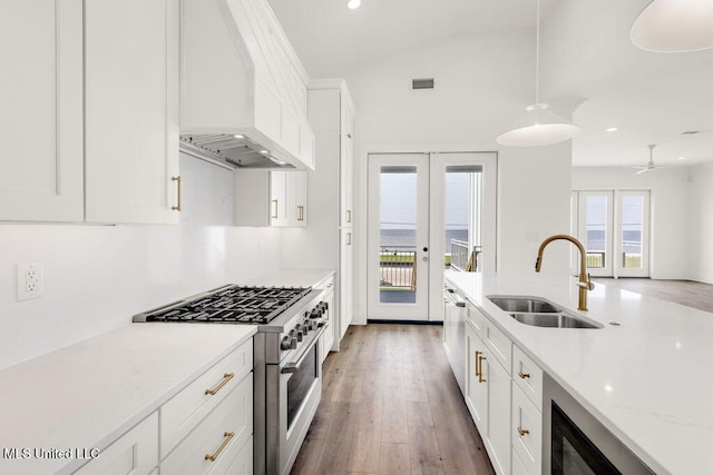 26470 W Beach Blvd, Pass Christian, MS 39571 - kitchen with appliances with stainless steel finishes, premium range hood, light wood-style flooring, white cabinetry, and recessed lighting