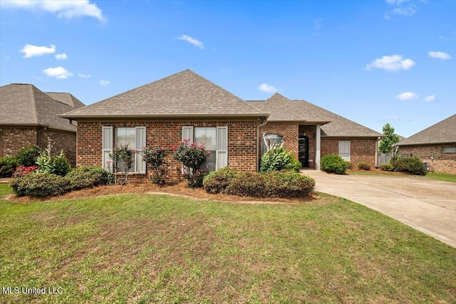 ranch-style house with brick siding, roof with shingles, and a front lawn