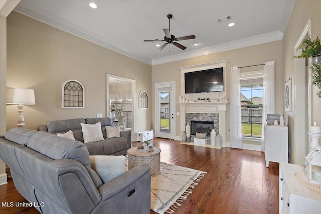 living area featuring visible vents, crown molding, ceiling fan, a fireplace with flush hearth, and dark wood finished floors