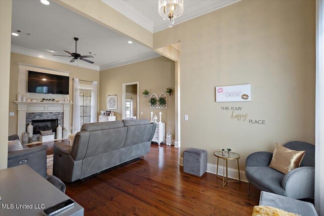 living area with ornamental molding, a ceiling fan, baseboards, visible vents, and dark wood-style floors