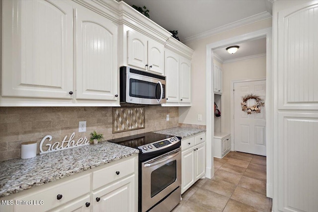 kitchen with light stone counters, ornamental molding, backsplash, and stainless steel appliances