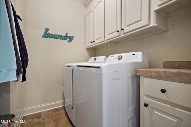 washroom with separate washer and dryer, cabinet space, and baseboards