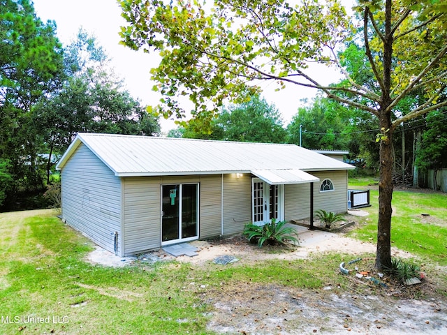 rear view of property featuring a lawn