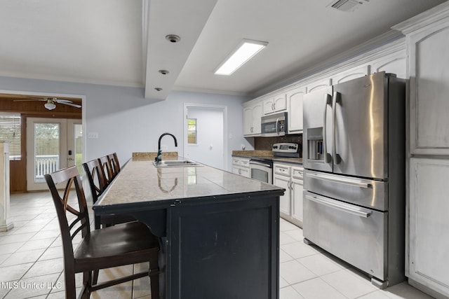 18401 Dogwood Ln, Saucier, MS 39574 - kitchen featuring light tile patterned floors, a peninsula, a breakfast bar, a sink, and stainless steel appliances