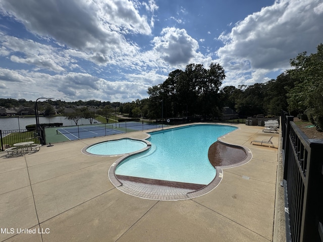 view of pool with a water view and tennis court