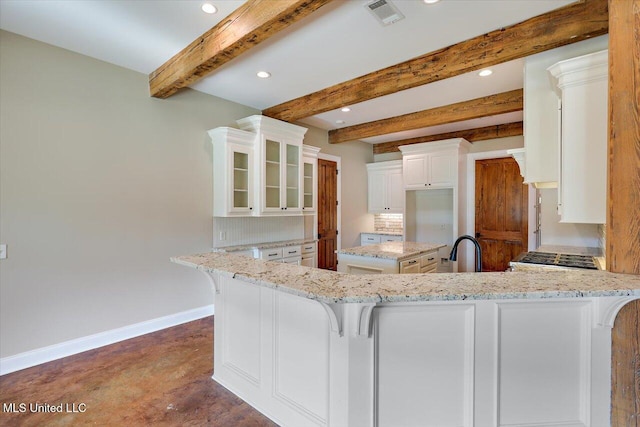 kitchen featuring white cabinetry, beam ceiling, kitchen peninsula, and light stone countertops