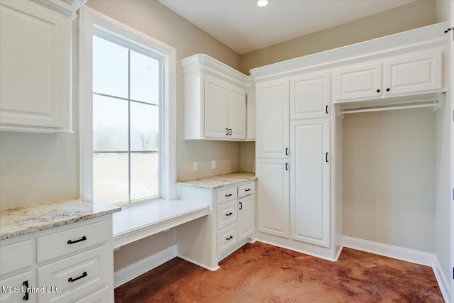 kitchen with light stone counters and white cabinetry