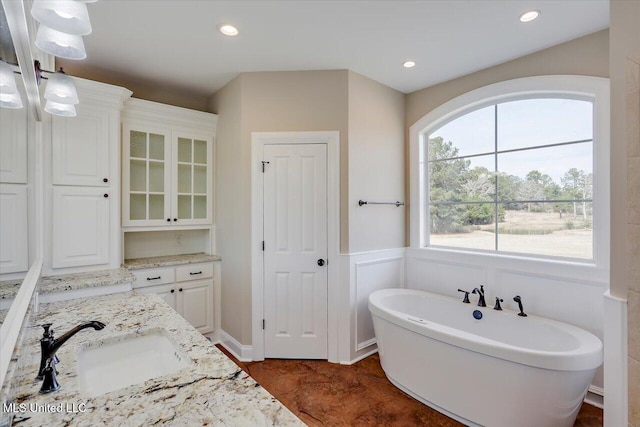 bathroom with hardwood / wood-style floors, vanity, and a bathing tub