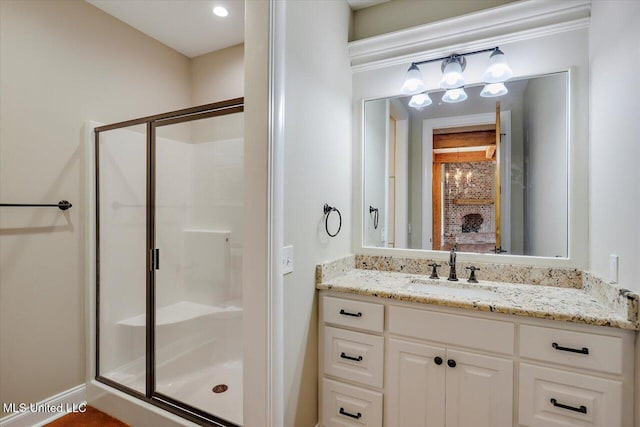 bathroom with ornamental molding, vanity, and a shower with shower door