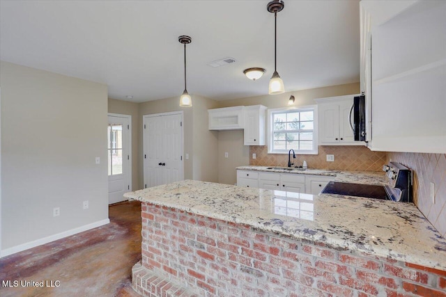 kitchen featuring range, pendant lighting, light stone counters, white cabinets, and sink