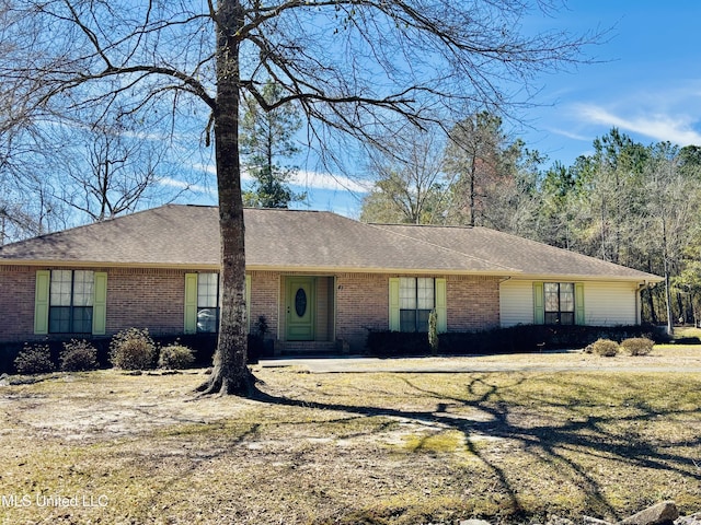 ranch-style home with brick siding and a shingled roof