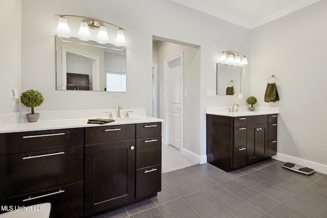 full bath featuring a sink, crown molding, baseboards, and two vanities