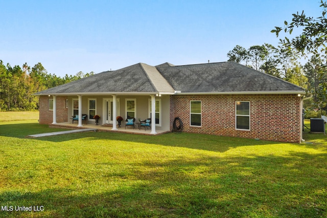 back of house featuring a yard, brick siding, central AC, and a shingled roof