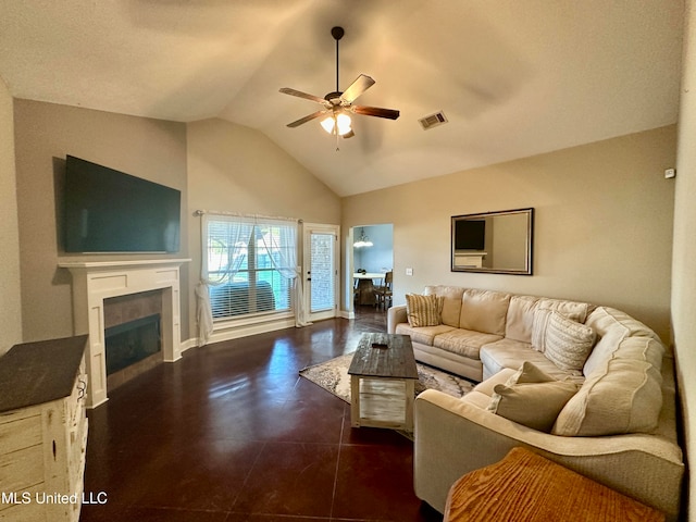 living room featuring dark tile patterned flooring, ceiling fan, a tiled fireplace, and vaulted ceiling