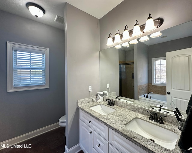 full bathroom featuring vanity, separate shower and tub, toilet, and a textured ceiling