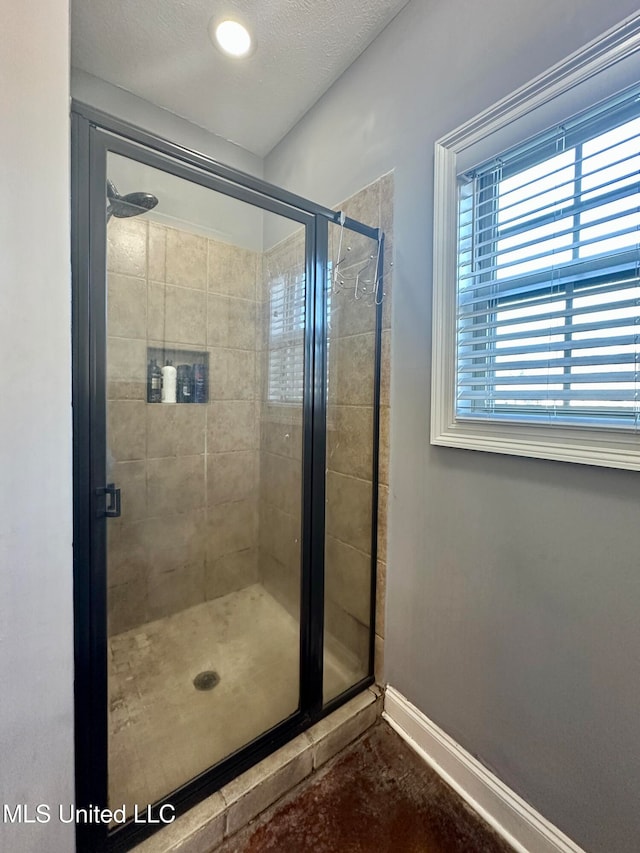 bathroom with a textured ceiling and walk in shower