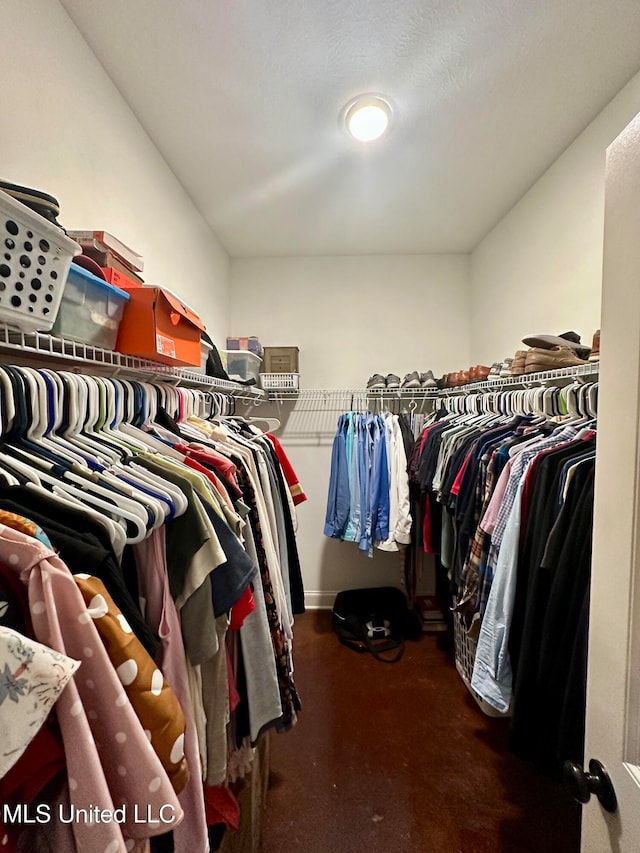 spacious closet featuring dark colored carpet