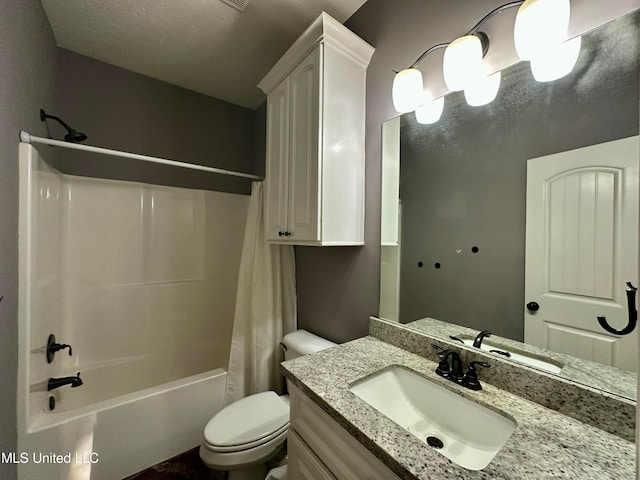 full bathroom with shower / bath combo, toilet, a textured ceiling, and vanity